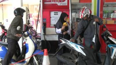 Motorcyclists at a petrol station in Indonesia