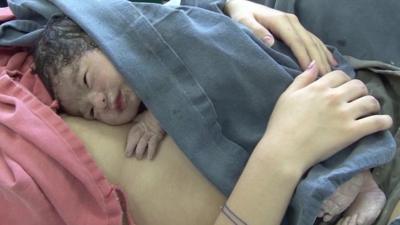 newborn baby in mother's arms