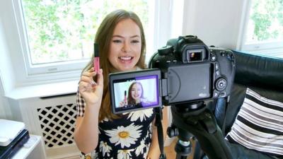 A woman making a video blog with camera