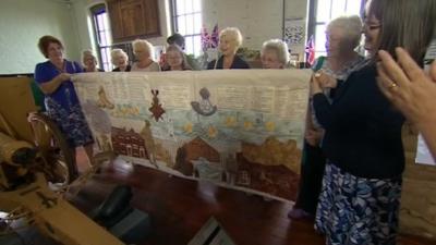 Women holding Hartlepool tapestry