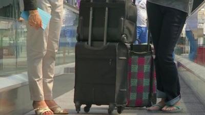 People with luggage on a travelator