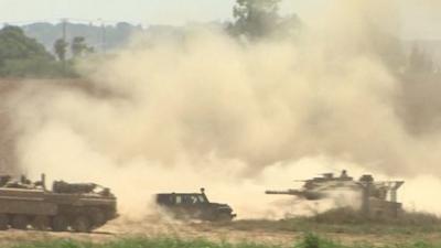 Dust flies as Israeli tanks await orders at Gaza border