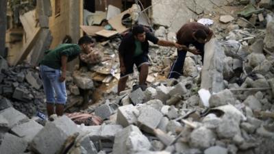 Palestinians search for the remains of bodies under rubble