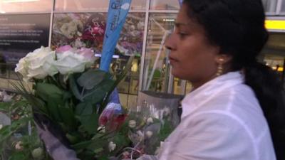 Member of staff clearing MH17 floral tributes at Schiphol airport