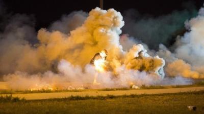 A protester throws a smoke bomb in Ferguson, Missouri