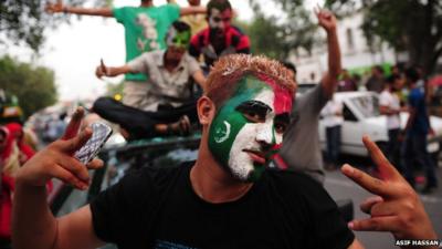 Pakistani supporters of cricketer-turned-politician Imran Khan, pose with their faces painted in party colours