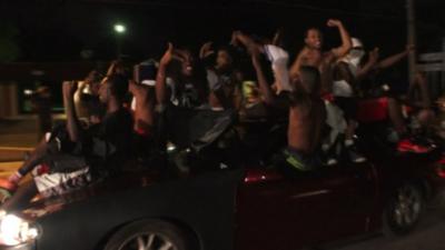 young men in on a car in a peaceful celebration in Missouri