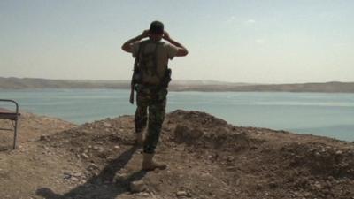 Kurdish soldier surveys dam