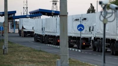 The driver of one of the Russian trucks in the aid convoy opens the awning of the vehicle for a border check in Donetsk - 20 August 2014