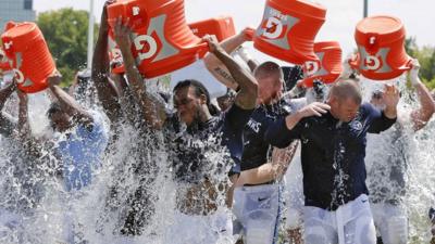 People pouring buckets of cold water over themselves