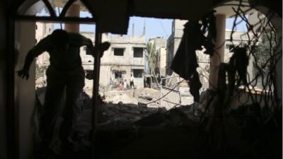 A Palestinian walks inside a house, which witnesses say was hit by an Israeli air strike