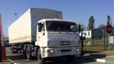 A truck from the Russian aid convoy to Ukraine stands in line as it returns to Russia over the border