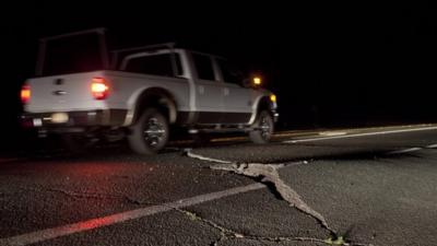 A truck navigates around a buckled section of California's Highway 12