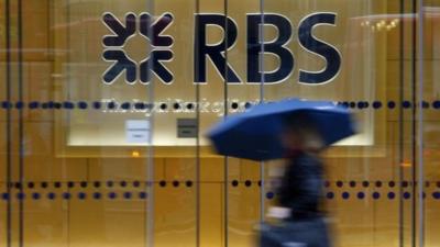 A woman walks past an RBS building