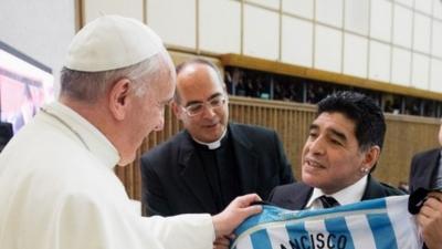 Former Argentina football player Diego Armando Maradona (R) presenting a personalised Argentina jersey to Pope Francis