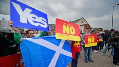 Yes and No campaigners wait for the departure of Labour leader Ed Miliband on the Scottish independence campaign trail on September 4, 2014 in Blantyre, Scotland