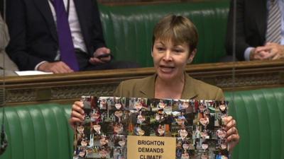 Caroline Lucas with poster at PMQs