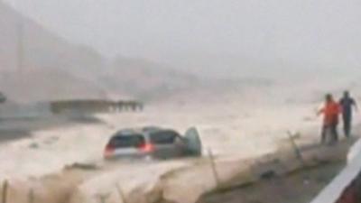 The minivan as it is swept away in flood water