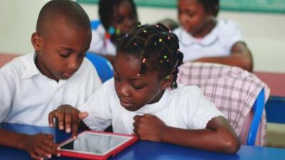 Students in the Ivory Coast looking at the Qelasy tablet in a classroom