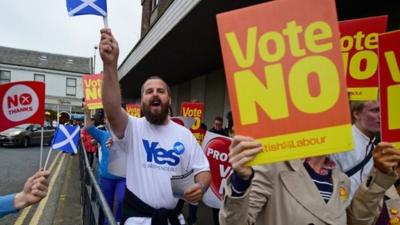 Yes and No supporters exchange words as Alistair Darling leader of the Better Together meets with members of the public during a walk about on September 15, 2014 in Kilmarnock, Scotland