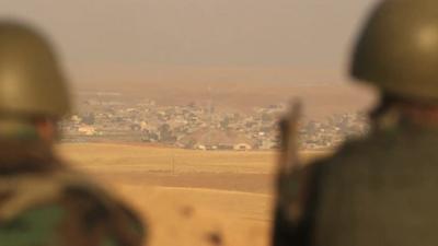 Soldiers look at a village