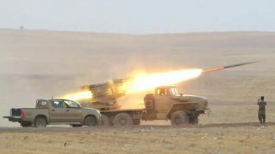 Kurdish forces launching rocket from vehicle