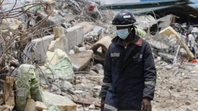 A rescue worker walks on the rubble of a collapsed building belonging to the Synagogue Church of All Nations in Lagos, Nigeria