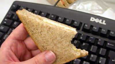 Office worker eating at his desk