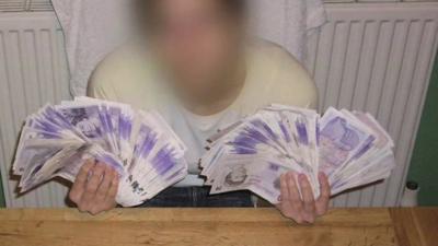 Person poses with cash