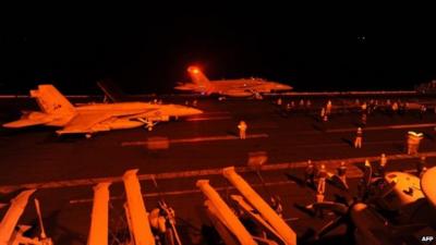 Fighter jets prepare to launch from the flight deck of a US aircraft carrier