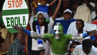 A Sierra Leone football fan with an anti-Ebola placard