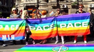 Gay rights activists holding a rainbow flag during a gay rights rally in downtown Belgrade