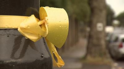 Yellow ribbon tied to a tree