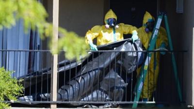 Hazmat team arranging plastic sheet