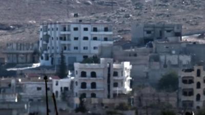 Black IS flag raised above Kobane, Syria