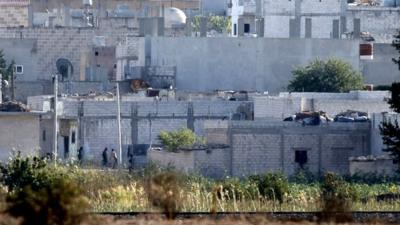 fighters on streets of Kobane, seen from border with Turkey