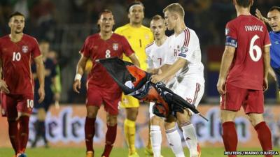 Balaj of Albania takes a flag depicting so-called Greater Albania which was flown over the pitch during their Euro 2016 Group I qualifying soccer match against Serbia at the FK Partizan stadium in Belgrade