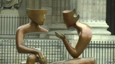 Bronze sculpture by French sculptor Etienne of two figures in conversation - part of an exhibition in the Saint-Germain district of Paris