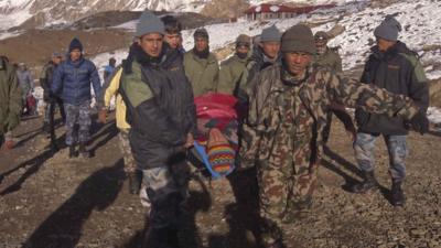 Nepalese army personnel carry a victim rescued from the avalanche at Thorang-La in Annapurna Region in this October 15, 2014 handout photo provided by Nepal Army