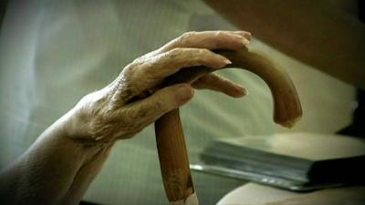 Frail hand on walking stick