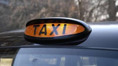 A black cab with its orange light on