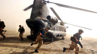 British Royal Marines of 45 Commando scramble out the back of a Chinook helicopter during an eagle vehicle check point (VCP) operation as part of the ongoing Operation Buzzard July 8, 2002 in southeastern Afghanistan