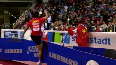 Chinese table tennis player Zhang Jike destroys two advertising boards in celebration after regaining his world title at the 2014 World Cup in Dusseldorf, Germany