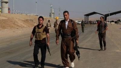 Kurdish Peshmerga fighters walk towards the front line at the Khazer checkpoint outside of the city of Irbil in northern Iraq,