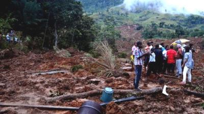 Sri Lankan residents stand at the site of a landslide