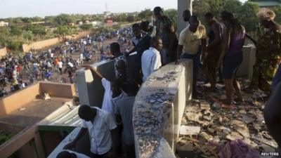 People walk around a looted house belonging to Francois, the younger brother of Burkina Faso"s former president Blaise Compaore