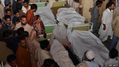 Pakistani relatives gather around the bodies of blast victims after a suicide bomb attack near the Wagah border