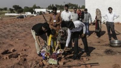 People lay wreaths at the scene of the murders