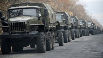 Unmarked military vehicles parked on a road outside the separatist rebel-held eastern Ukrainian town of Snizhne