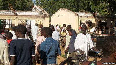 People inspect the damage roof at the site of a Suicide bomb explosion in Government Science Technical College Potiskum, Nigeria, Monday, Nov. 10, 2014